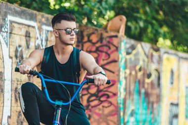 Genç yakışıklı hipster adam sokakta vintage Bisiklet ile eğleniyor açık poz