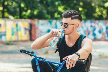 bmx bisiklet içecek su Şehir Parkı üzerinde genç adam
