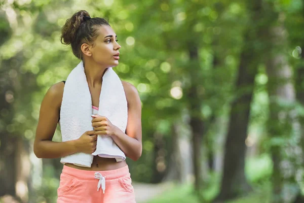 Портрет привлекательной уверенной улыбки молодая женщина бегунья с белым полотенцем на открытом воздухе для спорта бег трусцой упражнения здоровый образ жизни — стоковое фото