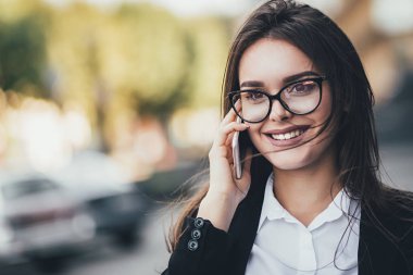 Çekici esmer işkadını üstünde hareket eden telefon istemcisi ile konuşuyor. yakın çekim