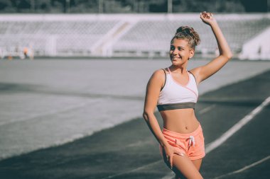 Seksi spor kız Stadı'nda poz. Fitness Spor şekil şort ve tank top stadyum kızla. Kız spor gün sonra