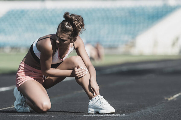 Women accident after exercise in stadium. Selective focus