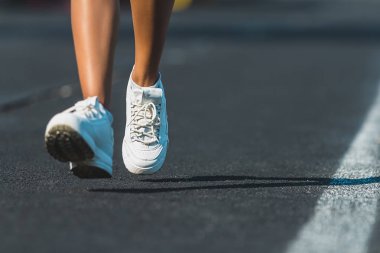 Zorlu yolda spor ayakkabı giyen bir atlet ayak yakın. Stadyum üzerinde çalışan egzersiz üzerinde iz