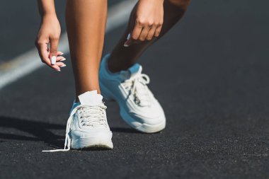 Kadın koşucu koşu parkuru, ayakkabılarını bağlamayı atlet bağcık bağlama