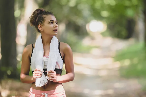 Молодая красивая и спортивная женщина после бега тренировки стоя на парке счастливой и расслабленной в концепции здорового образа жизни — стоковое фото