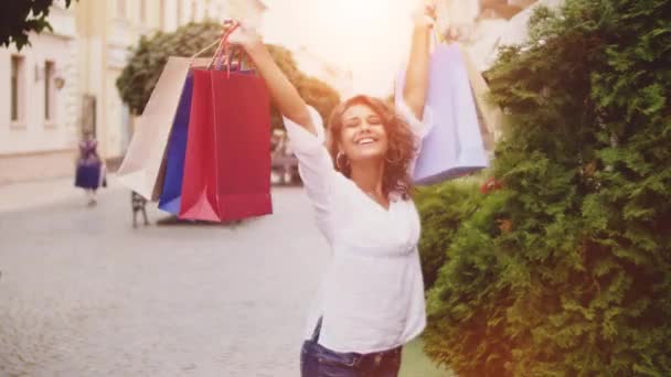 Bir şehirde alışveriş kadın. Parlak ışık etkisi arka planda — Stok video