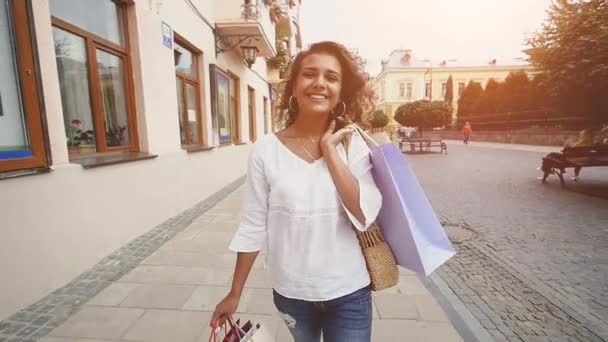 販売、消費者: 都市の時間をショッピングの後歩いて買い物袋を持つ自信を持って女性。スローモーション — ストック動画