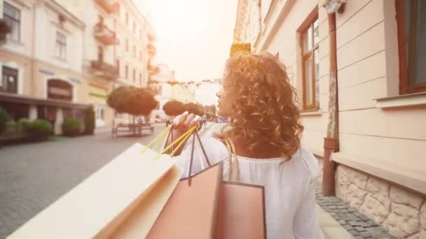 Vista posteriore di giovane turista donna è a piedi in città. Al rallentatore. sfondo luce solare — Video Stock