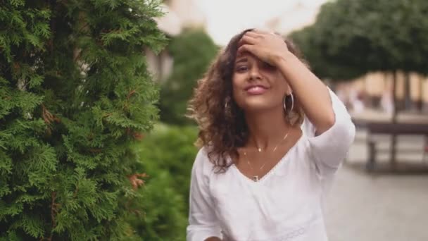 Dość Młoda Kobieta Kręcone Patrząc Prosto Aparatu Pogodny Nastrój Szczęśliwy — Wideo stockowe