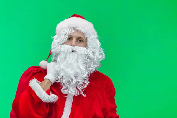 Chroma key. tired Santa Claus in white gloves carries a red bag with gifts over his shoulder