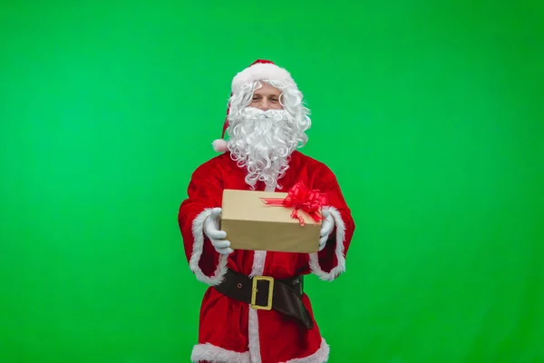Frohe Weihnachten. Weihnachtsmann im roten Anzug verteilt Geschenke in Schachteln auf grünem Bildschirm — Stockfoto