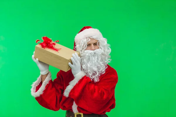 Santa Claus con caja de regalo contra chromakey. Santa interesante lo que está dentro de la caja —  Fotos de Stock