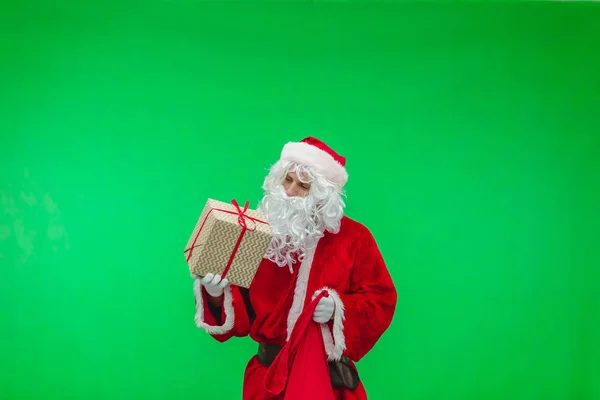 Una foto de Santa Claus recibiendo regalos de su bolso. cromakey —  Fotos de Stock