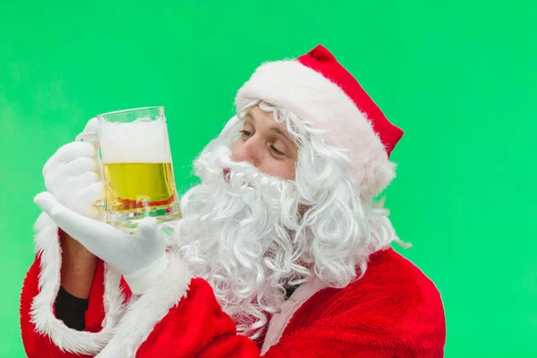Boże Narodzenie Santa patrzy na piękne szklankę piwa. kluczowanie. z bliska — Zdjęcie stockowe