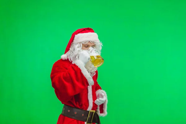 Funny santa drinks beer on green background