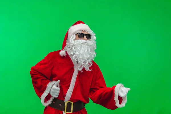 Santa claus poseren met zonnebril tegen groene achtergrond — Stockfoto