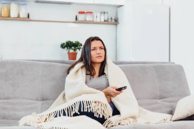 Kadın Tv kanepede görünüyor.