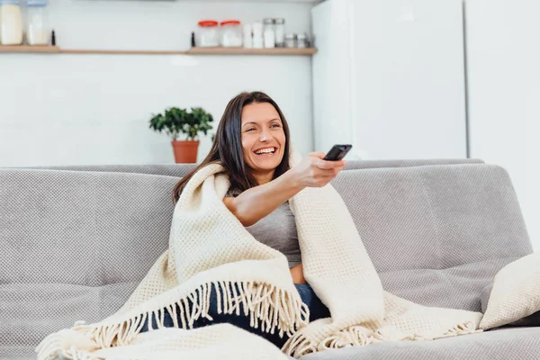 Kadın Tv kanepede görünüyor.