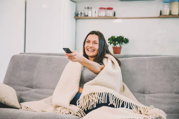 Kadın Tv kanepede görünüyor. — Stok fotoğraf