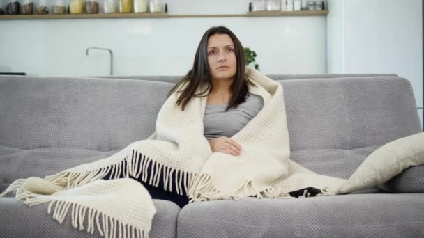 Una mujer está viendo la televisión con una manta — Vídeos de Stock