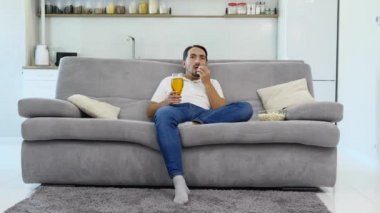 Bir adam bira ve bir film izlerken patlamış mısır sever