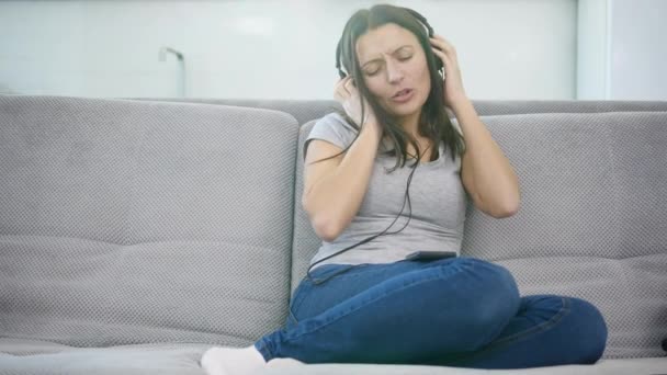 Woman listens to music in headphones — Stock Video