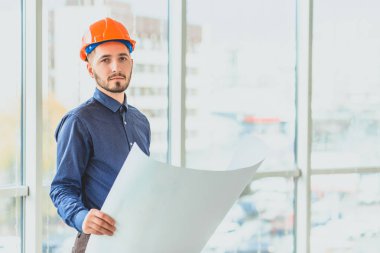 Portakal rengi bir varil içinde mimardır. Bir iş planı evi elinde tutmak.