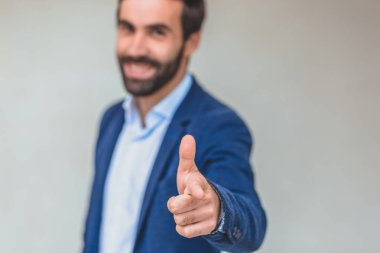 Mavi ceketli iş ortağı. Ciddi bir iş adamı gibi görünüyor. Güzel görünüyor. Gri arka planda.