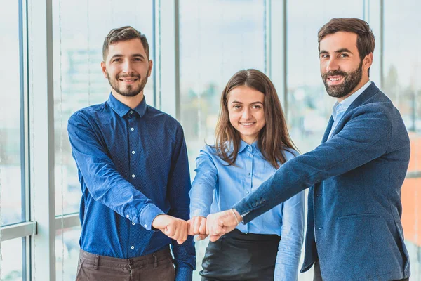 Três pessoas de negócios colocando um contrato colocar uma mão na mão . — Fotografia de Stock