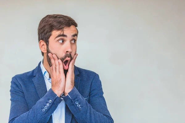 Affärspartner i en blå jacka. Med en blick av förvånad affärsman. Snyggt utseende. På en grå bakgrund. — Stockfoto