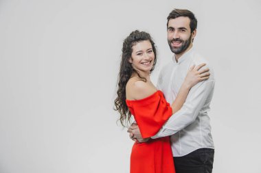 Uzun saçlı kadın ve erkek. Karısı kocası sarıldı. Arkadan görünüm. Sevgililer günü. Ben kadın kırmızı adam elbise beyaz gömlek giymiş.