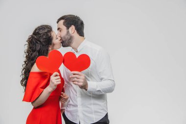 Güzel çekici, neşeli, pozitif çift. Evli tutun büyük kırmızı kartları ellerinde vardır. Bu süre boyunca öpüşüyorlar.