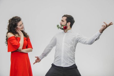 Birbirine bakarak iyi bir çift. Bir adam bir çiçek ağzında tutar. Beyaz bir arka plan üzerinde izole. Mutlu bir aile.
