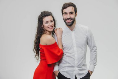 Uzun saçlı kadın ve erkek. Karısı kocasının sevgi ile omuz ellerini koymak. Sevgililer günü. Giyimli bir kadın kırmızı bir elbise, beyaz gömlekli bir adam.