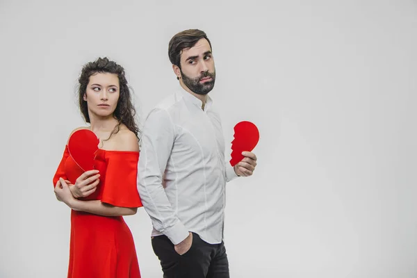 Retrato de um casal excessivo. Realização de duas partes do papel do coração. Isolado sobre um fundo branco . — Fotografia de Stock