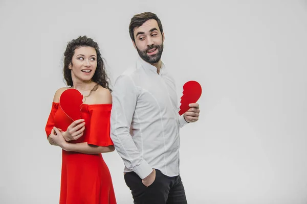 Retrato de um casal excessivo. Realização de duas partes do papel do coração. Isolado sobre um fundo branco . — Fotografia de Stock