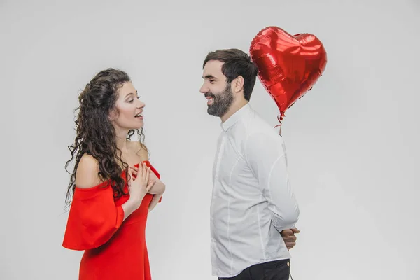 Valentine par. Skönhet flicka och hennes stiliga pojkvän håller hjärtat formade luftballong och kyssar. Lycklig glad familj. Kärlek. — Stockfoto