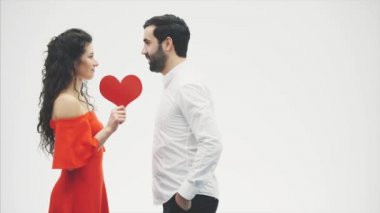 Güzel romantik çift beyaz arka plan üzerinde izole. Çekici genç kadın ve kırmızı kalpli yakışıklı el kucaklama. Mutlu Sevgililer Öpücük.
