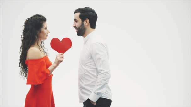 Krásný romantický pár izolovaný na bílém pozadí. Přitažlivá mladá žena a krásná ruka s červeným srdcem. Veselý Valentýnský polibek. — Stock video