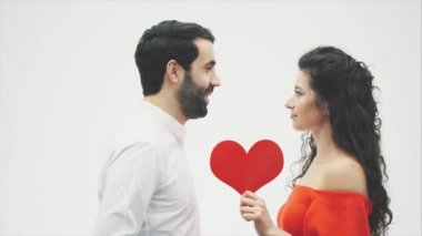 Güzel romantik çift beyaz arka plan üzerinde izole. Çekici genç kadın ve kırmızı kalpli yakışıklı el kucaklama. Mutlu Sevgililer Öpücük.