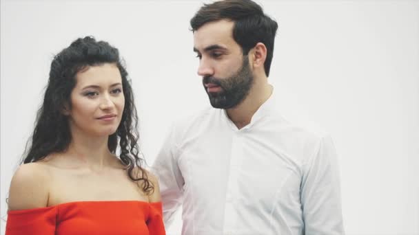 Beautiful romantic couple isolated on white background. An attractive young woman and a handsome man gives a red heart to her wife. — Wideo stockowe