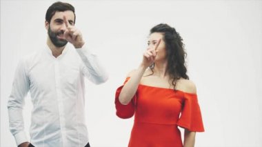 Güzel genç bir çift. İnanılmaz hava aşık, parmakları bir kalp öpüşme çizin. Sevgililer günü kutlama. Kırmızı elbiseli bir beyaz gömlek kız adam giymiş.