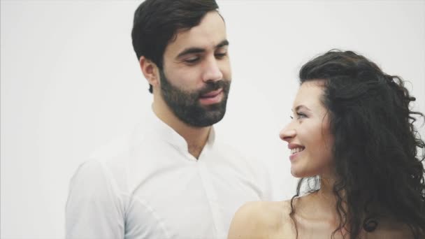 Hermosa pareja joven. Abrazar un beso y disfrutarlo juntos. Celebración de San Valentín. El tipo le da la caja de regalo a la chica en un vestido rojo . — Vídeo de stock