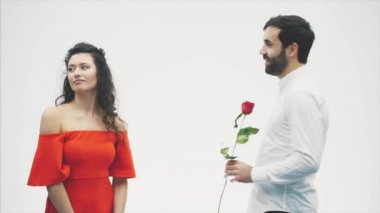 Bir klasik gömlek güzel zarif adam elinde kırmızı güllü. Beyaz bir arka plan üzerinde görüntülenir. Güller yakışıklı kız arkadaşına verir ve onu şefkatle öptü