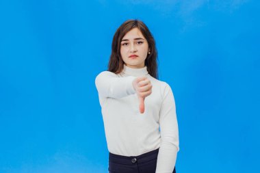 Yaşasın vererek mutlu bir genç kadın. Mavi bir arka plan üzerinde bir kız