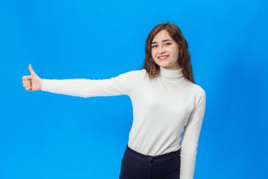 Genç kadın mavi bir arka plan üzerinde. Gülümseme ile mavi bir arka plan üzerinde bir kız