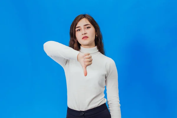 Joyeux jeune femme abandonnant les pouces. Une fille sur fond bleu — Photo