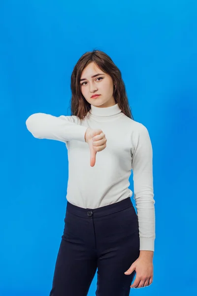 Feliz joven mujer dando pulgares hacia arriba. Una chica sobre un fondo azul —  Fotos de Stock