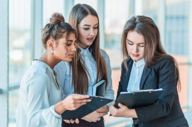 Dostu üç çok ırklı iş adamları grubu office içinde standında, kağıtları tutun, mali rapor çalışma.