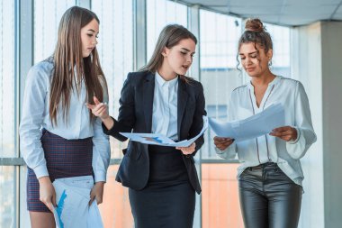 Üç genç güzel esmer iş Bayan ofiste. Tüm ciddi, birbirleriyle konuşmak